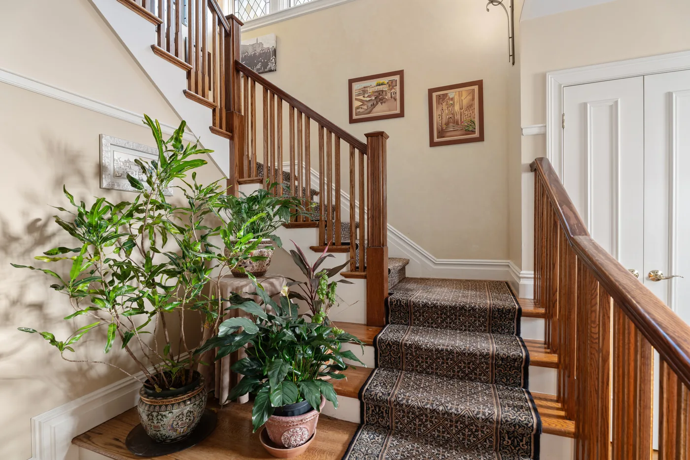 Foyer staircase with indoor greenery photographed for a New York City real estate listing.